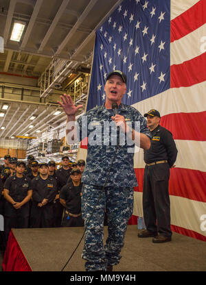 170925-N-DC385-528 SASEBO, Japan (Sept. 25, 2017) Vice Adm. Tom Rowden, commander, Naval Surface Forces, addresses Sailors during an all-hands call in the ship’s hangar bay of the amphibious assault ship USS Bonhomme Richard (LHD 6). Rowden is visiting Fleet Activities Sasebo, home of the 7th Fleet’s forward-deployed amphibious ships, to better understand forward-deployed readiness challenges and to discuss the role of the new command Naval Surface Group Western Pacific organization. (U.S. Navy photo by Mass Communication Specialist Seaman Cosmo Walrath/Released) Stock Photo