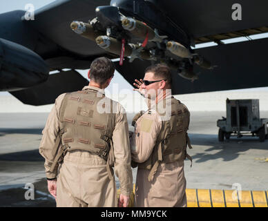 U.S. Air Force Capt. Micah McCracken, right, 69th Expeditionary Bomb Squadron aircraft commander, discusses the B-52 Stratofortress to U.S. Army Gen. Joseph Votel, left, U.S. Central Command commander, at Al Udeid Air Base, Qatar, Sept. 8, 2017.  Votel flew on a combat mission aboard a B-52 Stratofortress, and spent time talking with deployed Airmen at the 69th Expeditionary Bomb Squadron here. (U.S. Air Force photo by Tech. Sgt. Amy M. Lovgren) Stock Photo