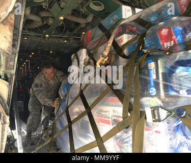 Staff Sgt. Jose Cepeda, 156th Maintenance Squadron, Puerto Rico Air National Guard, helps to unload a pallet of supplies from an Air Force C-130 Hercules aircraft at Muniz Air National Guard Base, Puerto Rico, Sept. 24, 2017. The Puerto Rico Air National Guard is working with numerous local and federal agencies in response to Hurricane Maria. (U.S. Air National Guard photo by Tech. Sgt. Dan Heaton) Stock Photo