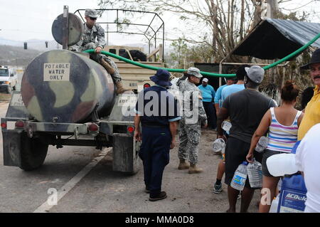 U.S. Soldiers assigned to the Puerto Rico National Guard, along with employees from the Aqueducts and Sewers Authority of Puerto Rico, distribute water for the communities of Utuado, Puerto Rico, Sept. 26, 2017. After the impact of Hurricane Maria, 2,175 service members, including the Puerto Rico National Guard, had been mobilized in the territory to support the efforts of the government in the reconstruction of the island.(U.S. Army National Guard photo by Sgt. Jose Ahiram Diaz-Ramos) Stock Photo