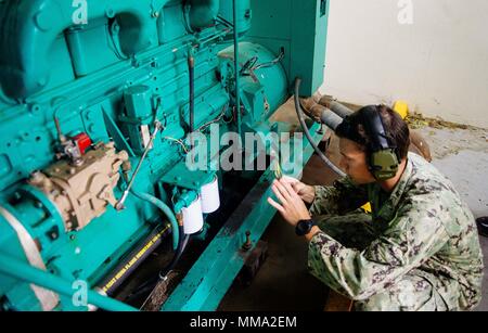 170926-N-IM651-006 UTUADO, Puerto Rico (Sept. 26, 2017) Construction Electrician 3rd Class Joshua Reding, assigned to Construction Battalion Maintenance Unit 202, inspects a generator at the Metropolitano De La Montana Hospital in Puerto Rico. The Department of Defense is supporting the Federal Emergency Management Agency, the lead federal agency, in helping those affected by Hurricane Maria to minimize suffering and as one component of the overall whole-of-government response efforts.  (U.S. Navy photo by Gunners Mate 1st Class Jonathan Eddy/Released) Stock Photo