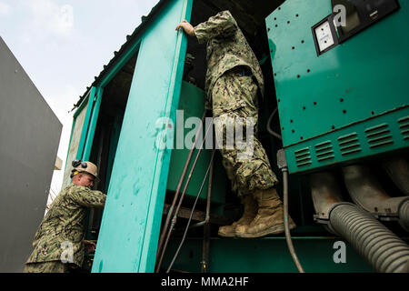 U.S. Navy Sailor Construction Electrician 2nd Class John McConnell, left, and Construction Electrician 2nd Class John R. Stewart, both with Amphibious Construction Battalion 2, begin working on a faulty generator as part of Hurricane Maria relief efforts at Ryder Hospital, Humacao, Puerto Rico, Sept. 27, 2017. The Department of Defense is supporting the Federal Emergency Management Agency, the lead federal agency, and local authorities in Puerto Rico with the combined goal of protecting the lives and safety of those in affected areas. (U.S. Marine Corps photo by Lance Cpl. Tojyea G. Matally) Stock Photo