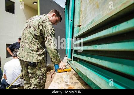 U.S. Navy Sailor Construction Electrician 2nd Class John R. Stewart with Amphibious Construction Battalion 2, operates on a faulty generator as part of the Hurricane Maria relief efforts at Ryder Hospital, Humacao, Puerto Rico, Sept. 27, 2017. The 26th Marine Expeditionary Unit, along with other services of the Department of Defense, is supporting the Federal Emergency Management Agency, the lead federal agency, and local authorities in Puerto Rico with the combined goal of protecting the lives and safety of those in affected areas. (U.S. Marine Corps photo by Lance Cpl. Tojyea G. Matally) Stock Photo