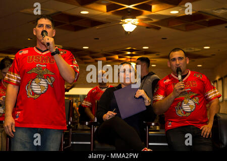 U.S. Marine Corps Sgt. Kurtis Anderson, left, a ground electronics telecommunications and information technology systems maintainer, and Sgt. Christian Morales, right, a tactical switching operator with Headquarters and Headquarters Squadron (H&HS), participate in karaoke during the 20th annual Single Marine Program’s End of Summer Party at Marine Corps Air Station Iwakuni, Japan, Sept. 27, 2017. The event gave Marines one last opportunity to enjoy the season with their peers as it turns to autumn. There was a karaoke competition, pool tournament and sumo wrestling competition. They held raffl Stock Photo