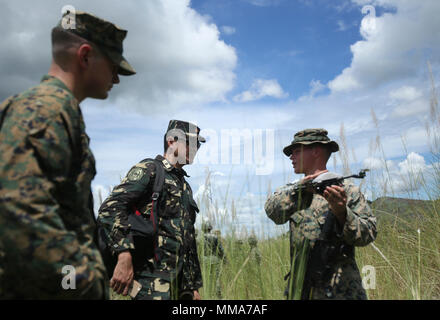 U.S. Marine Cpl. Lucas A. Dussaut, an assaultman with Lima Company, Battalion Landing Team, 3rd Battalion, 5th Marines, 31st Marine Expeditionary Unit, shows Philippine Army Maj. John Aling, with the Joint Command Training Center, and U.S. Marine Capt. David Murray, the ground liaison officer with the Joint US Military Assistance Group, an unmanned aerial surveillance system at Colonel Ernesto P. Ravina Air Base, Philippines on Oct. 2, 2017.  Elements of the 31st Marine Expeditionary Unit are currently in support of the 3rd Marine Expeditionary Brigade, participating in exercise KAMANDAG. Bila Stock Photo