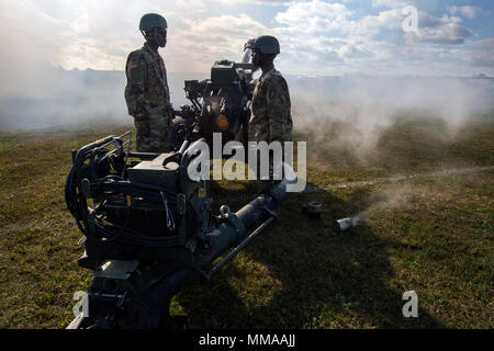 U.S. Army Soldiers of B Battery, 3-112th Field Artillery, New Jersey Army National Guard, stand at attention as smoke curls out of a 105mm expended blank round from M119A3 howitzer during a practice session prior to the 2017 New Jersey National Guard Military Review at the National Guard Training Center in Sea Girt, N.J., Oct. 1, 2017. The Military Review is a long-standing tradition that affords the governor – the commander-in-chief of the state militia – the opportunity to review the Soldiers and Airmen of the New Jersey National Guard. (New Jersey National Guard photo by Mark C. Olsen/Relea