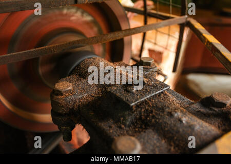 Detail on old rusty motor mechanism, rotor moving, metal axis covered with oil and dust. General manufacturing concept. Stock Photo