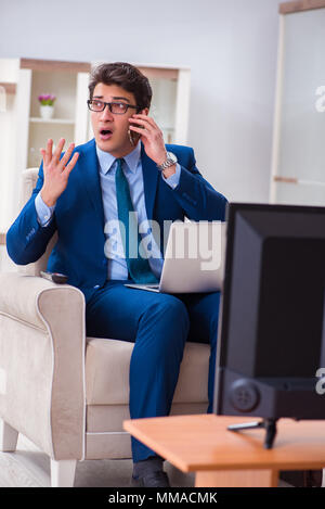 Businesman watching tv in office Stock Photo
