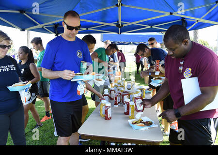 Approximately 1400 hamburgers and hot dogs were served at Sports Day. Military and Air Force civilian employees at Los Angeles Air Force Base, 61st Air Base Group and Space and Missile Systems Center, Calif., gather at the Fort MacArthur parade field in San Pedro, Calif. Oct. 4, 2016, to participate in “Sports Day” for a little squadron and inter-directorate competition in a variety of sports venues. The games foster physical, mental, and spiritual health and well-being, and a chance to win over-all points for the unit trophy, not to mention bragging rights between the SMC Directorates and 61s Stock Photo