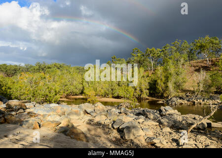 Black clouds and rainbow over bushland in Palmer River Goldfield, Far North Queensland, FNQ, QLD, Australia Stock Photo