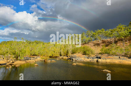 Black clouds and rainbow over bushland in Palmer River Goldfield, Far North Queensland, FNQ, QLD, Australia Stock Photo