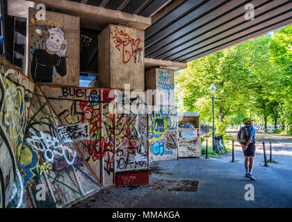 Berlin Mitte. Clothes recycling container & Street art and graffiti under S-bahn railway bridge across Spree River Stock Photo