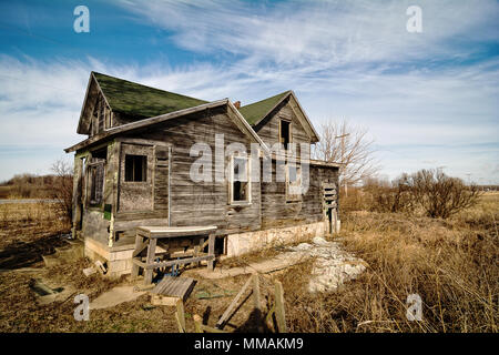 Photo of an old scary abandoned farm house that is deteriorating with time and neglect. Stock Photo