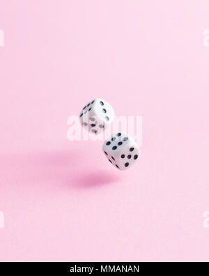 Two dice fall over pink background Stock Photo