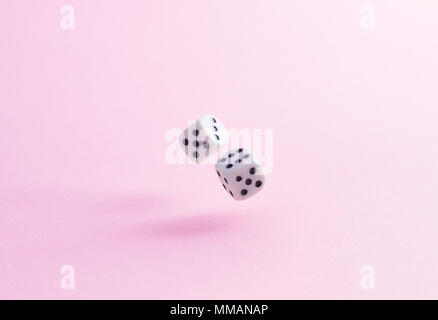 Two dice fall over pink background Stock Photo