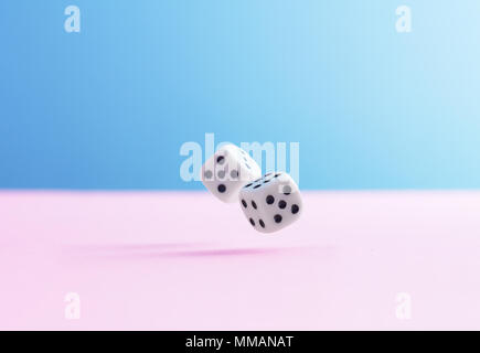 Two dice fall over pink background Stock Photo