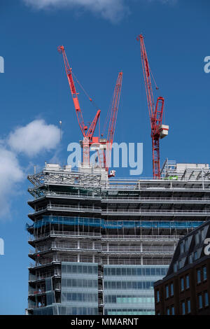 Construction cranes high on a building in the business area of Birmingham, UK. Stock Photo