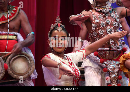 KANDY, SRI LANKA - JANUARY 27, 2015: Beautiful sinhalese woman performing traditional kandyan dance near a buddhist temple. Stock Photo