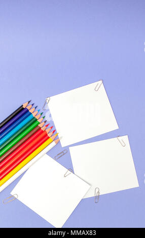 Blanks sheet of papers and color pencils on violet background for Projects and Announcements. Stock Photo