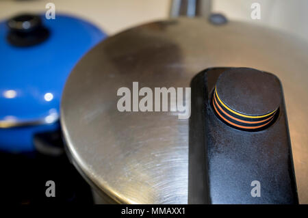 Stainless Steel Pressure Cooker at work. Rising indicator detail with markings to show the pressure level Stock Photo