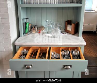 Falmouth, Cornwall, UK - April 12 2018: Self service cutlery, glasses, water and sauces on an antique dresser in a cafe Stock Photo