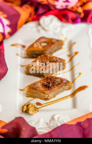 Traditional Azerbaijani Baklava with walnut in ceramic white plate. Selective focus. Stock Photo