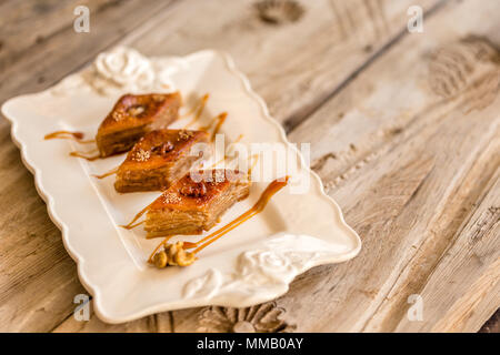 Traditional Azerbaijani Baklava with walnut in ceramic white plate. Horizontal composition. Selective focus. Stock Photo