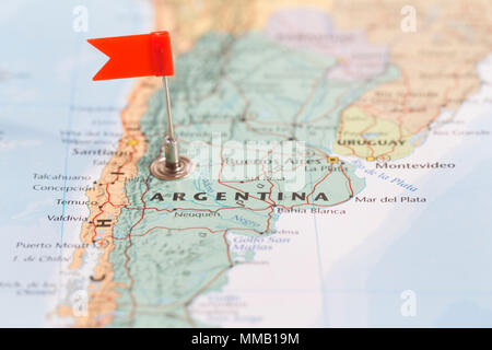 Small red flag marking the South American country of Argentina on a world map. Stock Photo