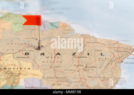 Small red flag marking the South American country of Brazil on a world map. Stock Photo