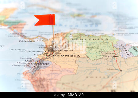 Small red flag marking the South American country of Colombia on a world map. Stock Photo