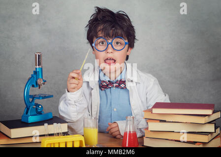 boy is making science experiments in a laboratory on gray background