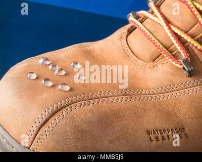 rain drops on waterproof clothes shoes boots with waterproof leather sign on a toe Stock Photo