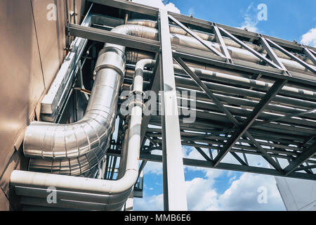 Industrial Pipe. Group of Factory Heat Pipe Water Chilling Air Ventilation transfer metal pipelines between building Stock Photo