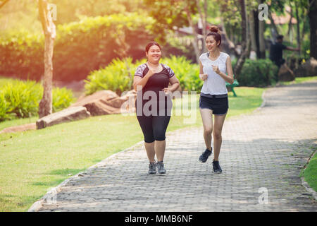 Two Asian girls fat and thin friend running jogging in the Park Stock Photo