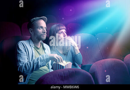 Teenager couple cuddling and watching the climax part of the movie Stock Photo