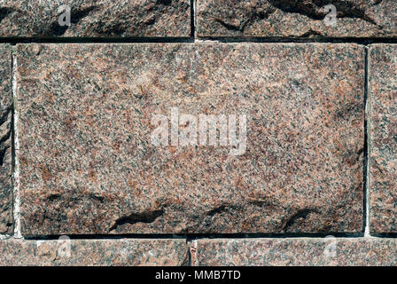 rough granite rectangular block in the composition of masonry wall Stock Photo