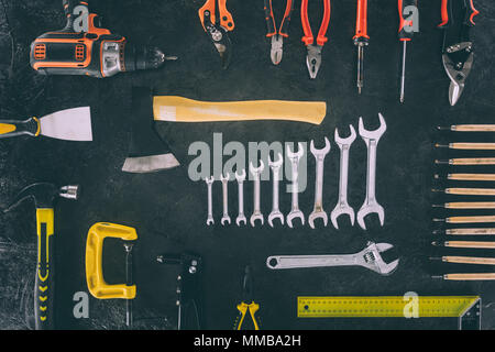 flat lay with axe and various arranged carpentry equipment on dark surface Stock Photo