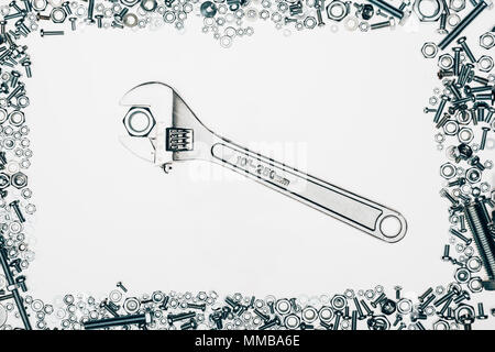 top view of arranged various metal engineering details with wrench in middle isolated on white Stock Photo