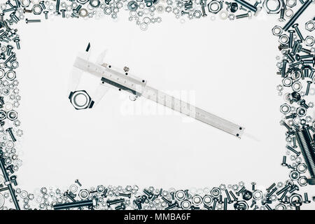 top view of arranged various metal engineering details with vernier caliper in middle isolated on white Stock Photo