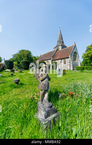 Stone angel statue child tombstone memorial at All Saints Parish Church, East Stratton, a small village near Winchester in Hampshire, southern England Stock Photo