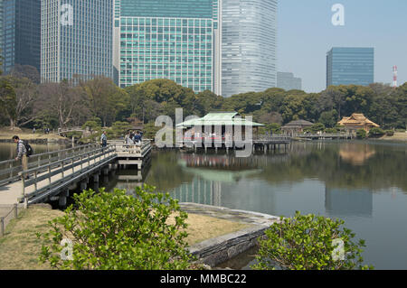 Pond and teahouses at Hamarikyu Gardens, Tokyo, Japan in cherry-blossom season Stock Photo