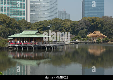 Pond and teahouses at Hamarikyu Gardens, Tokyo, Japan in cherry-blossom season Stock Photo