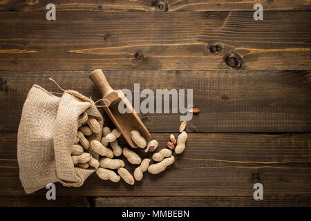 Organic Peanuts in Shells on Wooden Background. Copy Space. Stock Photo
