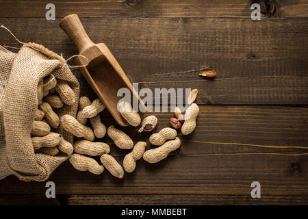 Organic Peanuts in Shells on Wooden Background. Copy Space. Stock Photo