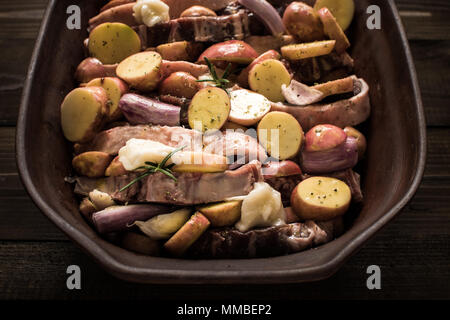 Lamb Loin Chops with Vegetables in Rustic Clay Dish Prepared for Roasting. Copy Space. Stock Photo