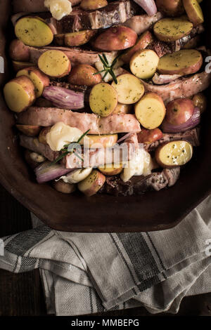 Lamb Loin Chops with Vegetables in Rustic Clay Dish Prepared for Roasting. Copy Space. Stock Photo