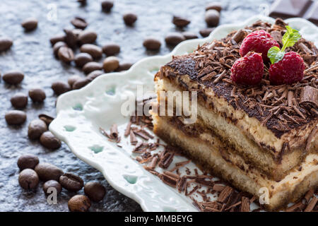 Dessert Tiramisu Cake with Grated Chocolate, Raspberry and Mint Stock Photo