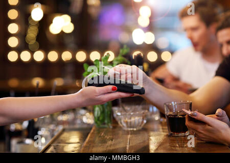 Group Of Friends Paying For Meal In Restaurant Stock Photo