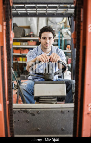 Caucasian man employee driving a forklift for a landscape company. Stock Photo