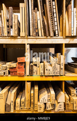 Large selection of wooden planks and boards stacked on shelves in a warehouse. Stock Photo